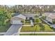 Aerial view of a well-maintained home featuring mature trees and a manicured lawn at 230 Lotus Dr, Safety Harbor, FL 34695