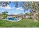 Lush backyard with a large pool, patio area, and mature trees for shade and privacy at 230 Lotus Dr, Safety Harbor, FL 34695
