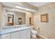 Bathroom with white cabinets, blue countertops, a large mirror, and natural light at 230 Lotus Dr, Safety Harbor, FL 34695