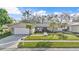 Charming single-story home with a well-manicured lawn and mature palm trees at 230 Lotus Dr, Safety Harbor, FL 34695