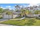 Charming single-story home with a well-manicured lawn and mature palm trees at 230 Lotus Dr, Safety Harbor, FL 34695