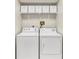 Practical laundry room with modern washer and dryer units, plus functional shelving for storage at 230 Lotus Dr, Safety Harbor, FL 34695