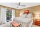Primary bedroom with king bed, ceiling fan, access to patio, and ample natural light at 230 Lotus Dr, Safety Harbor, FL 34695