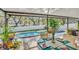 A covered patio features an outdoor dining set overlooking the pool at 230 Lotus Dr, Safety Harbor, FL 34695