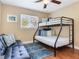 The bedroom features wood floors, natural light, a bunk bed and a comfortable couch at 2823 St Croix Dr, Clearwater, FL 33759