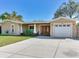 Charming single-story home featuring a well-maintained lawn, covered porch, and attached two-car garage at 2823 St Croix Dr, Clearwater, FL 33759