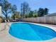 Backyard swimming pool with clear water surrounded by a concrete deck, lounging chairs, and wooden fence at 2823 St Croix Dr, Clearwater, FL 33759