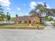 Inviting single story home with an orange facade, well-manicured lawn, and mature shade trees at 2912 Spaniel Ln, Seffner, FL 33584