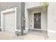 Exterior front door and garage with a small white rock garden at 2925 Beluga Bay Dr, Odessa, FL 33556