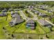 Aerial view of a home in a residential neighborhood with well-maintained lawns, mature trees, and screened-in pools at 3020 Silva Wood Dr, Valrico, FL 33596