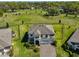 Expansive aerial view of a two-story home with a manicured lawn, mature trees, and a three-car garage at 3020 Silva Wood Dr, Valrico, FL 33596