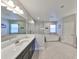 Luxurious bathroom with dual vanities, a large mirror, and a soaking tub for ultimate relaxation at 3020 Silva Wood Dr, Valrico, FL 33596