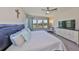 Bright bedroom with ceiling fan, three windows, and a tufted headboard at 3020 Silva Wood Dr, Valrico, FL 33596