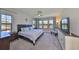Bright bedroom featuring large windows, a ceiling fan, and a serene color palette at 3020 Silva Wood Dr, Valrico, FL 33596