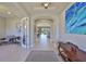 A bright hallway with an arched doorway leads to a living room, and is decorated with stylish furniture at 3020 Silva Wood Dr, Valrico, FL 33596