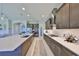 A modern kitchen features sleek dark cabinets, a large island with white countertops, and stainless steel appliances at 3020 Silva Wood Dr, Valrico, FL 33596