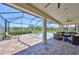 Covered patio with ceiling fan, dining, and view of the pool, spa, and lawn at 3020 Silva Wood Dr, Valrico, FL 33596