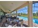 Covered patio with ceiling fan, dining, and view of the pool, spa, and lawn at 3020 Silva Wood Dr, Valrico, FL 33596