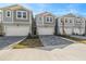 New townhomes featuring two-car garages and neutral color schemes on a sunny day at 31484 Woodland Race Loop, Wesley Chapel, FL 33545