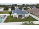 Aerial view of a home with screen enclosed patio and fenced backyard with lush grass at 3215 Coconut Grove Rd, Land O Lakes, FL 34639