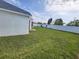 Spacious, well-maintained backyard with lush grass and white vinyl privacy fence at 3215 Coconut Grove Rd, Land O Lakes, FL 34639