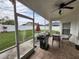Relaxing screened patio with outdoor furniture, grill, and view of the lush backyard at 3215 Coconut Grove Rd, Land O Lakes, FL 34639