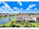Aerial view of a two-story home with a screened-in pool area, near a pond and beautifully landscaped yard at 32423 Rosewood Meadow Ln, Wesley Chapel, FL 33543