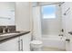 Well-lit bathroom with white tile, modern vanity, updated fixtures, and a shower-tub combination at 32423 Rosewood Meadow Ln, Wesley Chapel, FL 33543