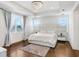 Bedroom with tray ceiling, chandelier, hard wood floors and two windows at 32423 Rosewood Meadow Ln, Wesley Chapel, FL 33543
