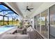 View of the covered patio with comfortable seating, ceiling fans and a screened-in pool at 32423 Rosewood Meadow Ln, Wesley Chapel, FL 33543