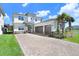 Beautiful two-story home with a paver driveway, three-car garage, stone accents, and well-maintained landscaping at 32423 Rosewood Meadow Ln, Wesley Chapel, FL 33543