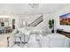 Bright, open living room featuring white decor, modern lighting, and stylish staircase at 32423 Rosewood Meadow Ln, Wesley Chapel, FL 33543