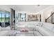 Spacious living room flows into the kitchen and dining areas with large windows and white couches at 32423 Rosewood Meadow Ln, Wesley Chapel, FL 33543