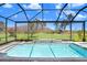 View of sparkling pool with spa and screened in lanai enclosure and lush lawn at 32423 Rosewood Meadow Ln, Wesley Chapel, FL 33543