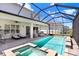 A screened in pool and spa with an extended patio with seating and lounge chairs at 32423 Rosewood Meadow Ln, Wesley Chapel, FL 33543