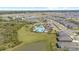 Aerial view of the community pool with lush landscaping near the lake, playground, and beautiful surrounding neighborhood at 33064 Tulip Petal Ln, Wesley Chapel, FL 33545
