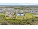 Aerial view of the community pool, playground, and surrounding neighborhood with lush landscaping and a beautiful lake at 33064 Tulip Petal Ln, Wesley Chapel, FL 33545