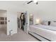 White bedroom with walk-in closet, ceiling fan, and neutral decor, creating a serene atmosphere at 33064 Tulip Petal Ln, Wesley Chapel, FL 33545