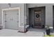 Townhome featuring gray front door with a wreath and attached one-car garage with black accents at 33064 Tulip Petal Ln, Wesley Chapel, FL 33545