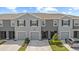 Two-story townhome showcasing a gray facade, garage, driveway, and manicured front lawn at 33064 Tulip Petal Ln, Wesley Chapel, FL 33545