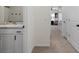 Hallway featuring a view into a bathroom with white cabinetry and a gray countertop at 33064 Tulip Petal Ln, Wesley Chapel, FL 33545