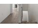 Neutral hallway with tan carpet, leading towards stairs with white trim at 33064 Tulip Petal Ln, Wesley Chapel, FL 33545