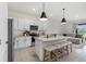 Open kitchen featuring a large island with seating, stainless steel appliances, and an adjacent living area at 33064 Tulip Petal Ln, Wesley Chapel, FL 33545