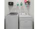 Laundry room with white washer and dryer under wire rack at 33064 Tulip Petal Ln, Wesley Chapel, FL 33545