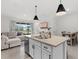 Open-concept living area with kitchen island, a comfortable sofa, and sliding glass doors to the patio at 33064 Tulip Petal Ln, Wesley Chapel, FL 33545