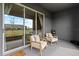 Outdoor porch with a pair of cushioned chairs and large glass sliding doors at 33064 Tulip Petal Ln, Wesley Chapel, FL 33545