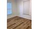 This bedroom features wood-look floors and natural light from two windows at 38030 Howard Ave, Dade City, FL 33525