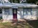 Charming home featuring a metal roof, white siding, and a distinctive purple door at 38030 Howard Ave, Dade City, FL 33525