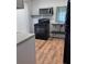 Galley style kitchen with black appliances, dark shelves, and wood-look floors at 38030 Howard Ave, Dade City, FL 33525