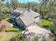 Stunning aerial view of a spacious home with a brick driveway, lush landscaping, and a screened-in pool area at 405 Apache Trl, Brandon, FL 33511